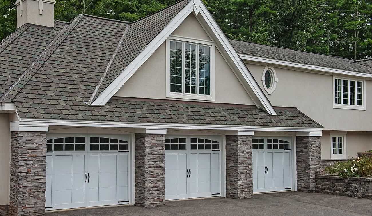 White carriage garage doors with an overlay and black handles and hinges 