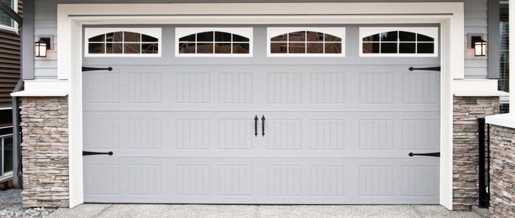 Gray garage door with white windows and black handles and hinges